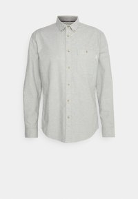 Camisa de manga larga gris claro hecha de tejido texturizado, con cuello tipo polo, bolsillo frontal y botones de latón a lo largo del placket.