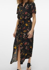 Blommig midiklänning i svart tyg, korta ärmar, knäppning framtill, midjesnörning, sidoflikar, med flerfärgade blommönster.