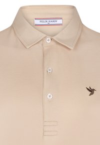 Beige polo-shirt lavet af tekstureret stof, med krave, tre knapper og en lille broderet brun kolibri på brystet.