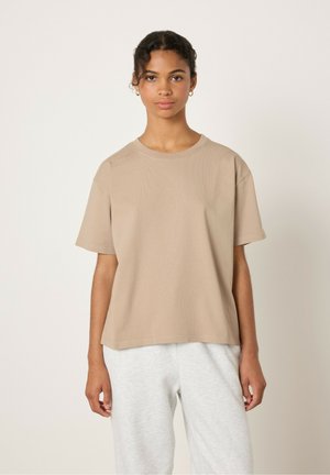 Beige katoenen T-shirt met een ronde hals, korte mouwen en een relaxed fit. Heeft een gestructureerd oppervlak en valt boven de taille.