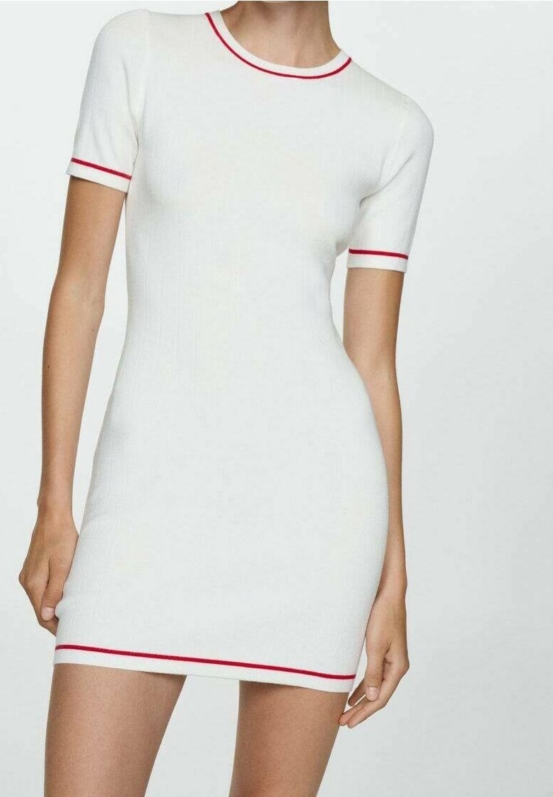 Femme portant une robe blanche ajustée à manches courtes avec une bordure rouge au col, aux poignets des manches et à l'ourlet, sur un fond uni.