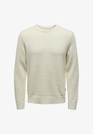 Világos bézs kötött pulóver, kerek nyakkivágással, hosszú ujjakkal és bordás mandzsettával. Texturált minta sima felülettel.