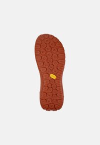 Gummisula i orange, med cirkulära och ovala mönster för grepp, samt en upphöjd Vibram-logotyp på mitten.