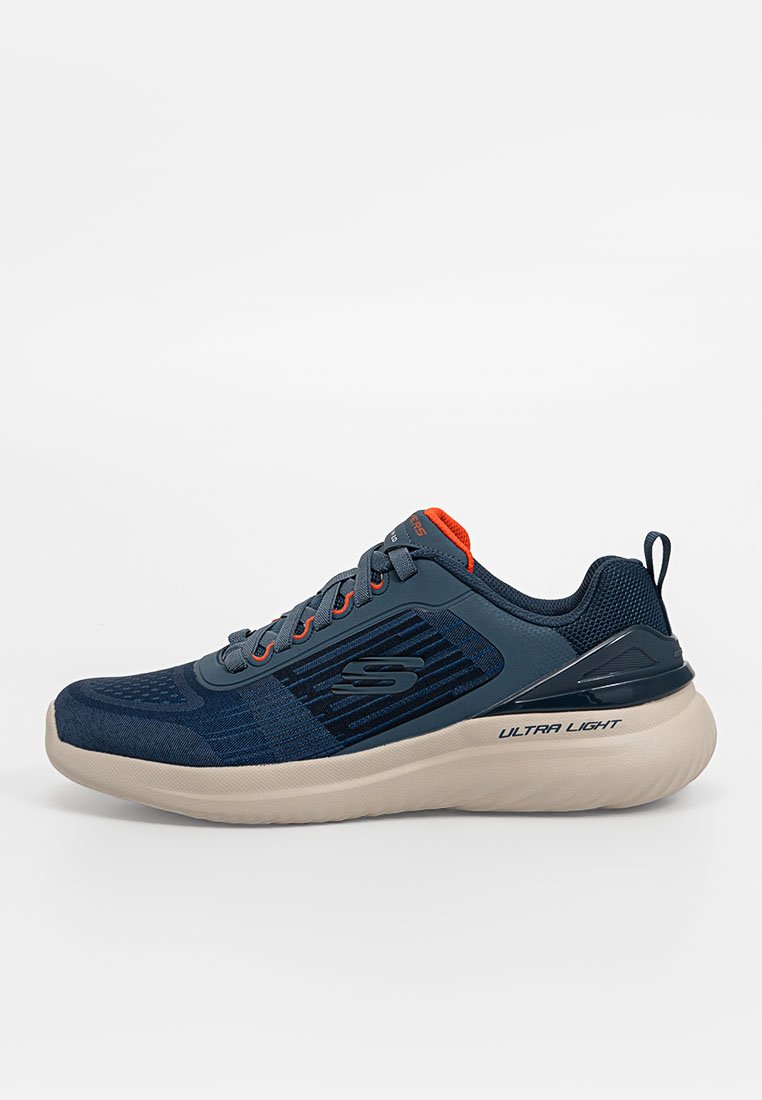 Zapatilla atlética azul con parte superior de malla, diseño texturizado y acentos naranjas. Suela gruesa de color claro etiquetada como "ULTRA LIGERA" en el costado.