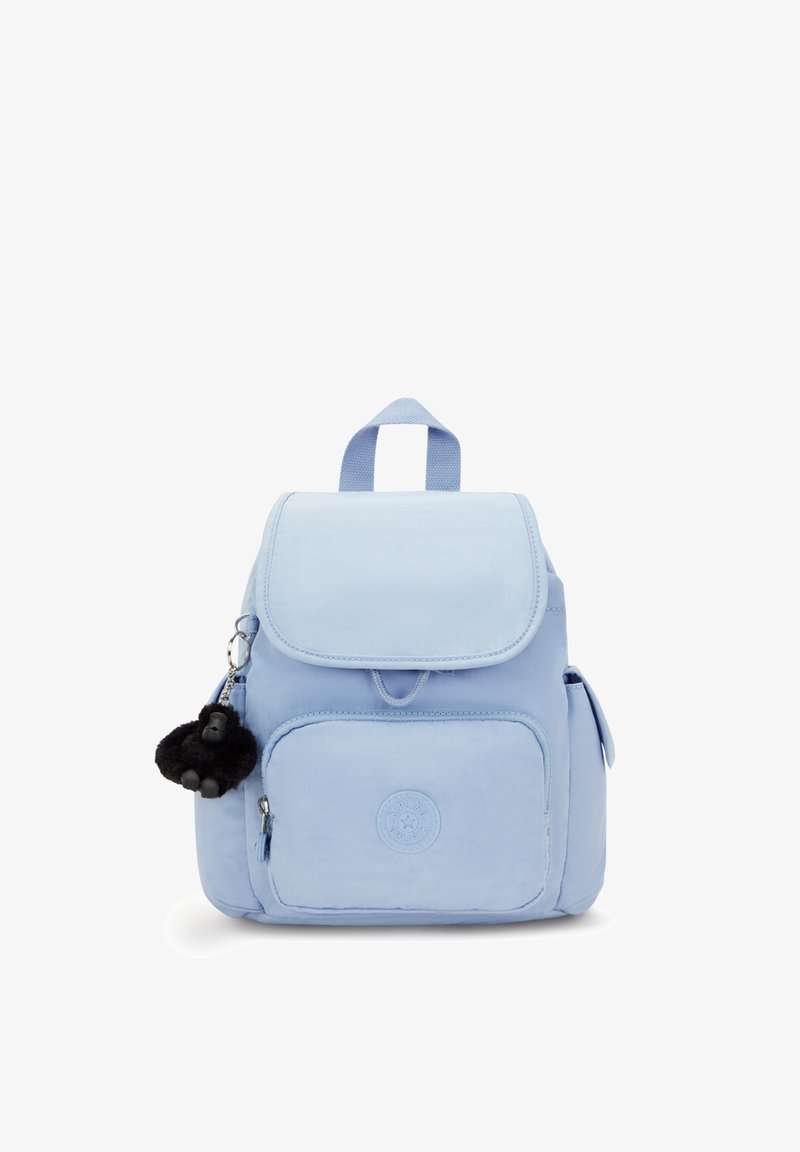 Mochila azul claro con cierre de solapa, bolsillo frontal y bolsillos laterales. Presenta un logo redondo y un llavero de un mono de peluche negro.