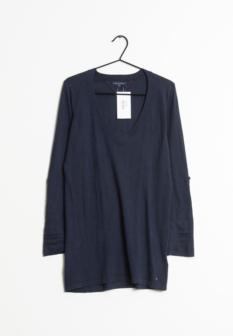 Pull col en V manches longues bleu marine suspendu sur un cintre noir avec une étiquette de prix blanche sur un fond blanc.