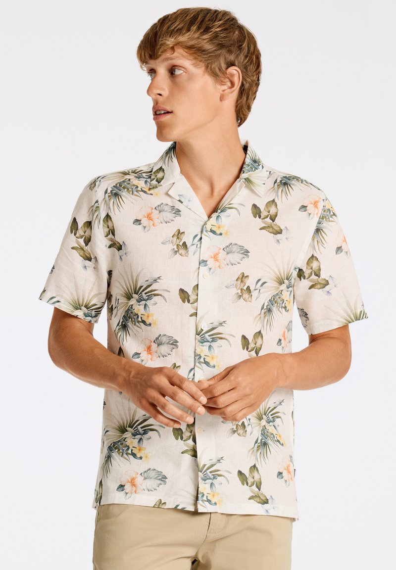 Camisa de manga corta de tela ligera con un estampado floral en verdes, rosas y amarillos. Diseño con cuello y botones, y un corte relajado.