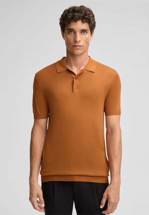 Pomarańczowa koszulka polo z krótkim rękawem, charakteryzująca się klasycznym kołnierzykiem, trzema guzikami oraz gładką fakturą. Minimalistyczny design z żebrowanymi akcentami.