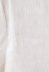 Lättviktig, strukturerad tyg i mjuk vit med fina, subtila linjer. Mjuk yta med en lätt genomskinlig kvalitet. Perfekt för lager-på-lager.