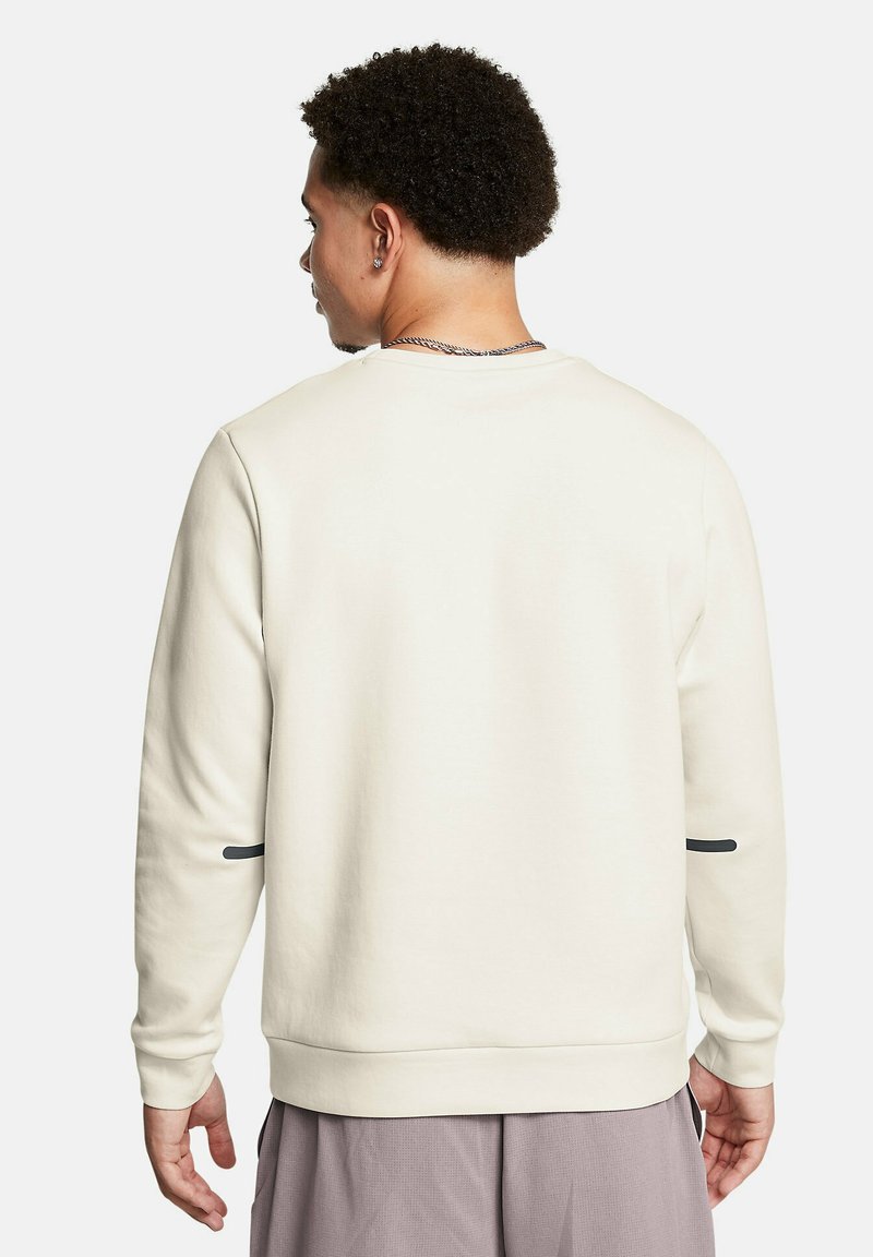 Crème sweatshirt met lange mouwen, ronde halslijn en gestructureerde stof. Heeft een zwart accent op de linkermouw en geribbelde manchetten.