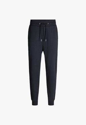 Pantaloni jogger blu navy con vita regolabile tramite laccetto, gambe affusolate e polsini elastici. Realizzati in un morbido tessuto in cotone misto per il massimo comfort. Presentano un design minimale.