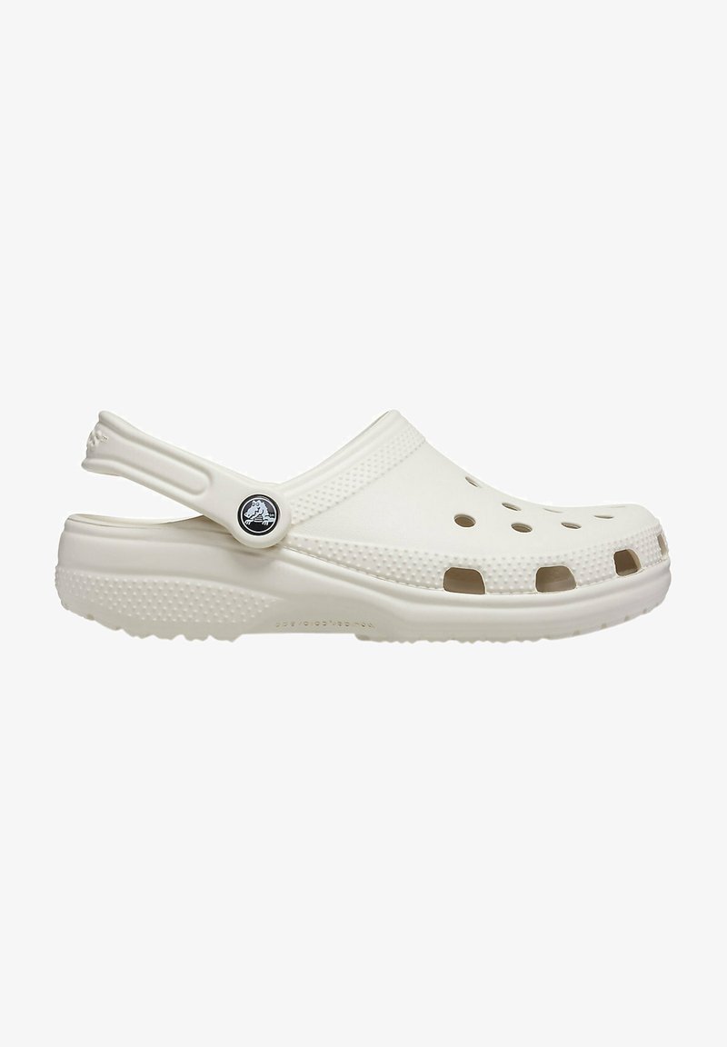 White clogs made of EVA material. Features ventilation holes, back strap, textured upper, and a round logo accent on the side.