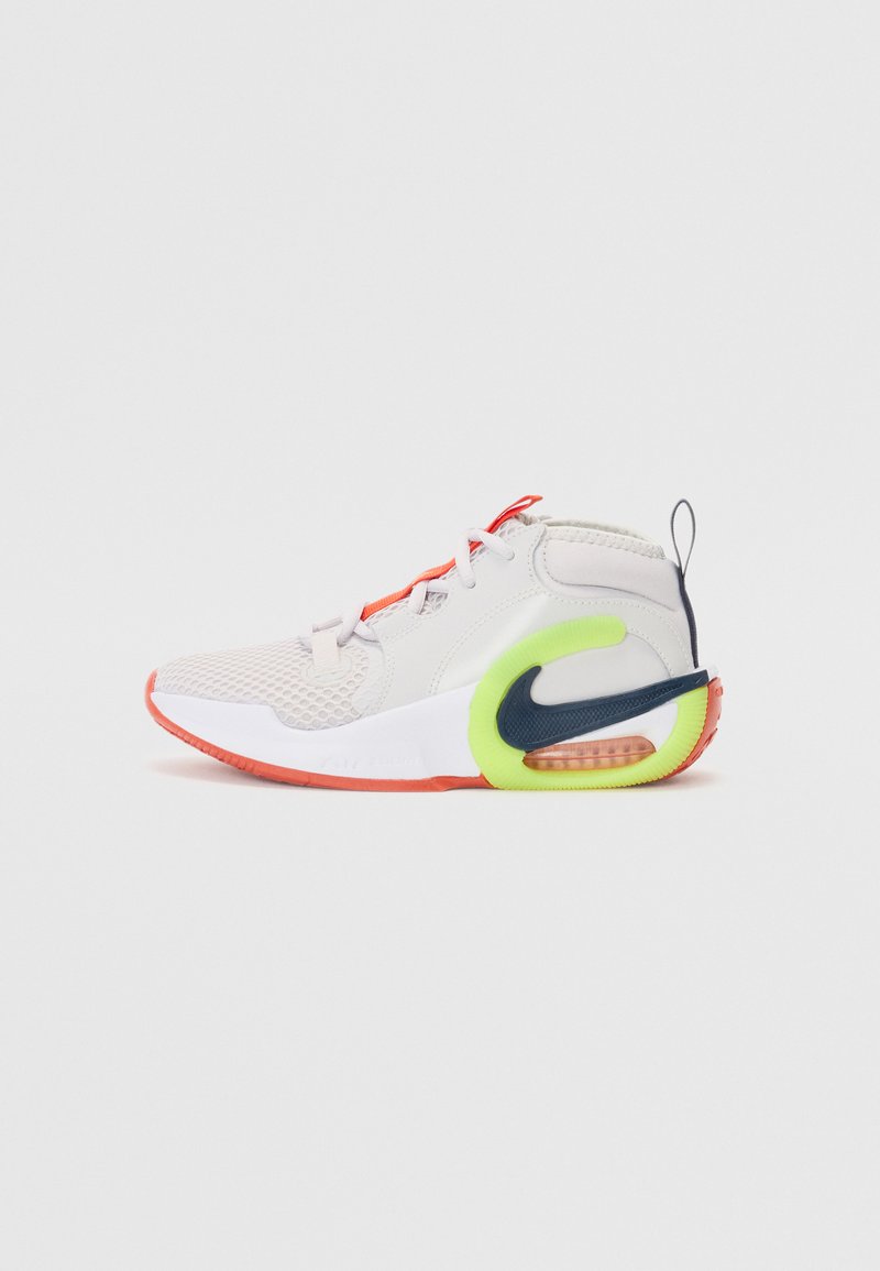 Sko med en lys grå mesh-overdel, røde detaljer, en neongrønn hæl og svart swoosh-logo. Har en polstret såle med synlig luftenhet.