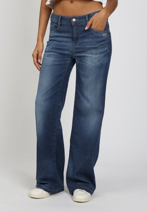 Weit geschnittene dunkelblaue Jeans aus Denim mit einem dezenten Verwaschungseffekt, Fünf-Taschen-Design und einem Metallknopfverschluss.