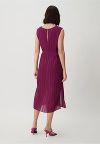 Fuchsia Plisseemidi-Kleid mit Schlüssellochausschnitt, tailliertem Bund und glatter Textur. Kombiniert mit passenden fuchsia farbenen Absatzsandalen.
