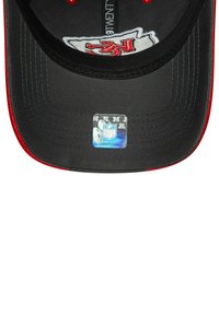 Black cap with a curved brim, red accents, and embroidered white design. Features a holographic NFL sticker on the underside of the brim.