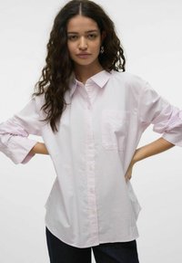 Camisa de botones de rayas en rosa claro, con mangas largas, un solo bolsillo en el pecho y un corte relajado, fabricada con una tela suave.