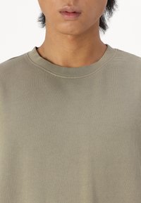 Licht olijfgroene sweatshirt met een geribbelde ronde hals en een textuurstof, met een relaxte pasvorm en minimale stiksel details.
