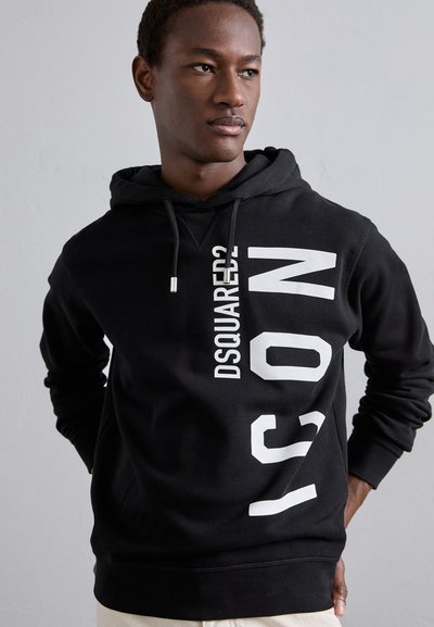 Schwarzer Baumwoll-Hoodie mit einem vertikalen weißen Aufdruck mit "DSQUARED2" und "ICON." Enthält eine Kapuze mit Kordelzug und gerippte Bündchen.
