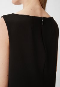 Schwarzes ärmelloses Kleid aus strukturiertem Stoff, mit einem dezenten Ausschnitt und einem Reißverschluss hinten.