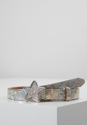 Lesklý úzký pásek s irizujícími šupinami a stříbrnou přezkou ve tvaru hvězdy leží na bílém povrchu.