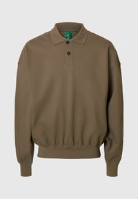 Brūns polo krekls ar garām piedurknēm, apkaklīti, divu pogu aizdari un elastīgu jostasvietu; materiāls izskatās mīksts un ar tekstūru.