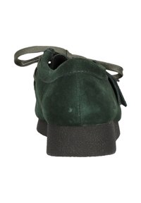 Vihreät samettikengät, joissa on karkea musta kumipohja. Varustettu pehmustetulla kielillä ja nauhoilla. Takakuvassa korostuu matala profiili.