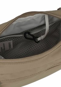 Sacchetto in tessuto beige con interni in rete, dotato di chiusura con zip e gancio nero per un attacco sicuro. Texture liscia e cuciture discrete.