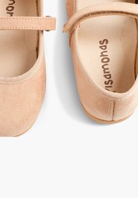 Zapatos Mary Jane de ante beige claro con puntera redondeada, cinta elástica, plantilla acolchada y suela de goma lisa.