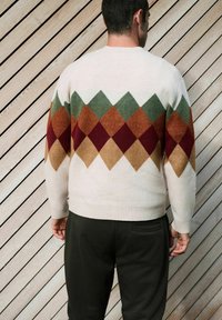 Kreemikas cardigan roosa, pruuni, oranži ja burbooni mustriga. Omab ribadena lõppu ja mansette. Kandmine mustade pükstega.