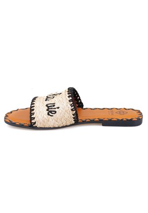 Woven slide sandals with a natural straw upper, featuring a black embroidered design and a tan leather footbed. Black trim surrounds the edges.