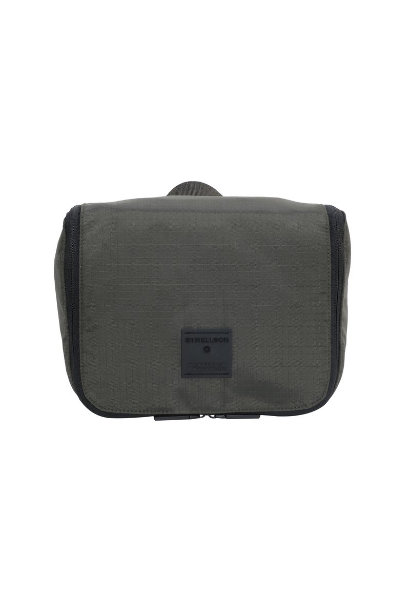 Borsa in tessuto verde scuro con una forma strutturata, dotata di una chiusura con zip e un patch logo frontale. Texture liscia e design minimalista.