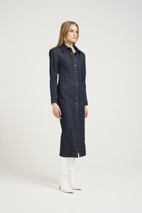 Denim-mekko, jossa on istuva siluetti, pitkät hihat ja etupainikekiinnitys. Tumansininen väri hienolla tekstuurilla, yhdistettynä valkoisiin saappaisiin.