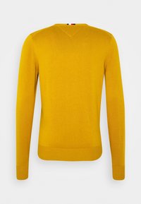 Gelber gestrickter Pullover mit langen Ärmeln, V-Ausschnitt, gerippten Manschetten und Saum. Glatte Textur in einheitlicher Farbe. Rückansicht dargestellt.