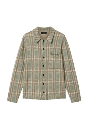 Chemise à manches longues boutonnée avec un motif à carreaux vert clair et beige, poche poitrine, et bords effilochés au col et à l'ourlet.