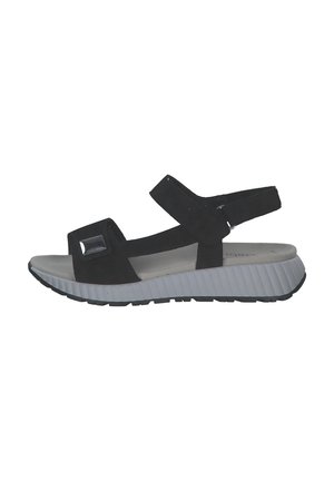 Black suede sandal with a thick white rubber sole, adjustable straps, and square cut-out detail on the upper. Lightweight design.