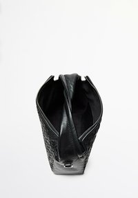 Borsa in pelle nera con trama intrecciata, chiusura con zip e una singola tracolla. Interno rivestito con un materiale morbido. Vista dall'alto.