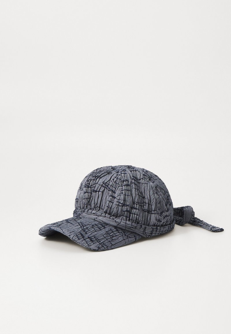 Blue textured cap with a curved brim, featuring a crinkled pattern and a tie at the back for adjustment. Made of soft, lightweight material.