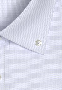 Colletto di camicia a quadri blu chiaro con un motivo testurizzato e un bottone argentato. Il tessuto appare liscio e leggero.
