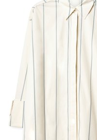 Kremo spalvos marškiniai su vertikaliomis šviesiai mėlynomis juostelėmis, ilgomis rankovėmis, klasikinio apykaklės dizaino, mygtukų užsegimu ir lygiu medvilnės tekstūru.