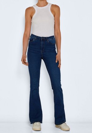 Blå flarejeans i denim med en slät textur; har midjeband, framfickor och sydda detaljer längs sömmarna.