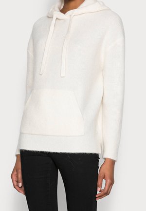 Off-white huvtröja i mjukt, texturerat tyg, med en framficka och snörning. Lätt lös passform med sidslitsar.
