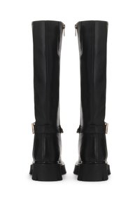 Botas de cuero negras hasta la rodilla con cierres de cremallera, detalles de hebilla y suelas gruesas y acampanadas. Textura suave; diseño alto y ajustado.