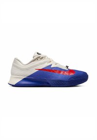 Scarpa sportiva Nike in bianco, rosso e blu. Presenta una tomaia testurizzata, un grande swoosh e un design della suola audace con un motivo di battistrada distintivo.