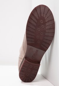 Beige suede boot with a textured, ridged burgundy rubber sole, featuring a slightly rounded toe and s.Oliver branding on the sole.