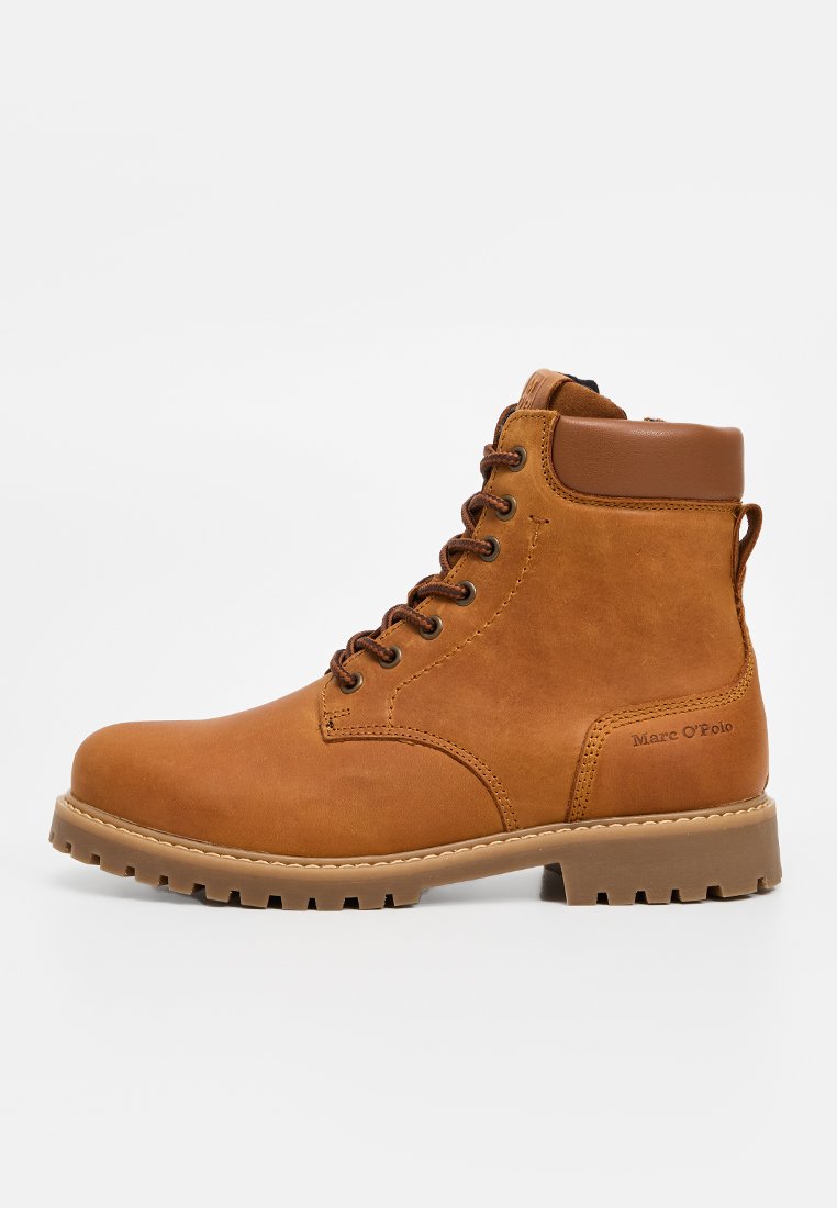 Bottines en cuir marron avec un bout rond, œillets en métal, semelle en caoutchouc épaisse et col rembourré. Détails du logo sur le côté.