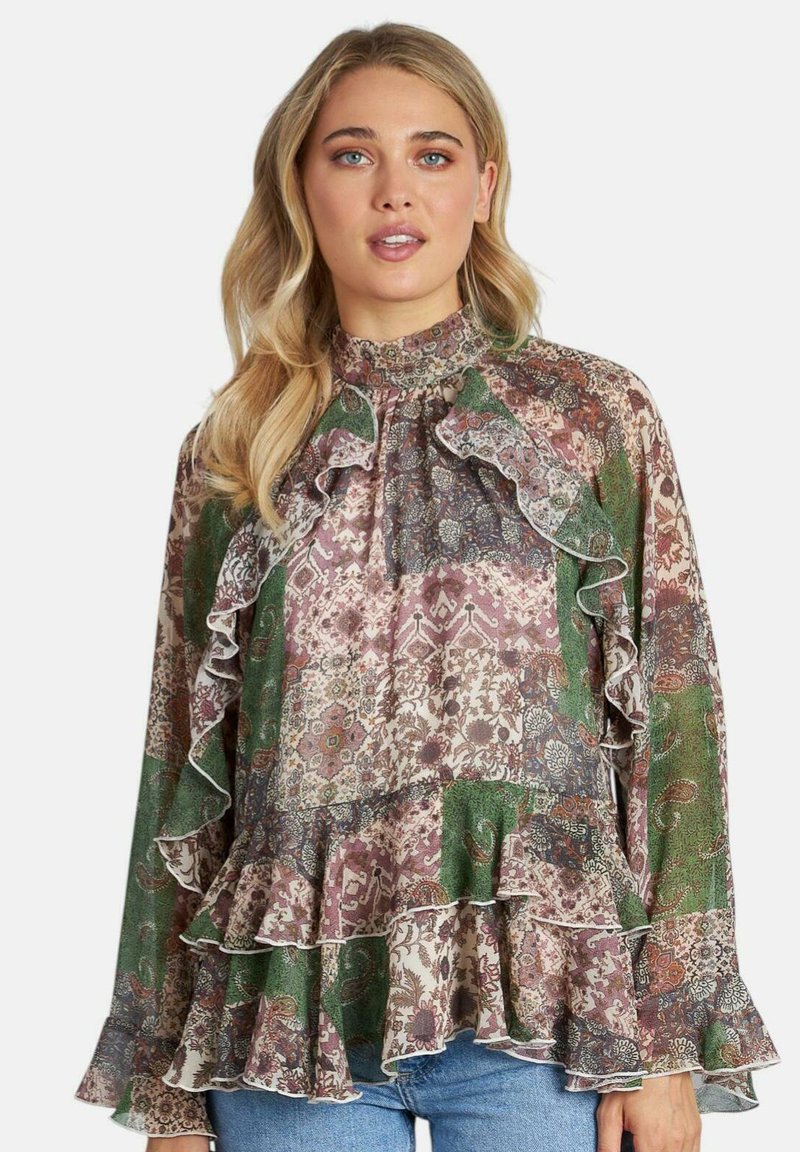 Blusa a maniche lunghe con volant e collo alto. Motivi floreali multicolor in verde, rosa e viola. Tessuto leggero con vestibilità fluida.