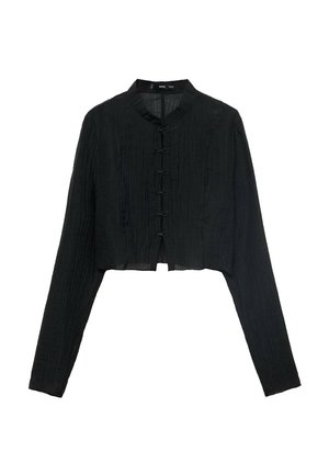 Veste noire courte avec manches longues, en tissu texturé, col mandarin et boutons décoratifs en forme de nœud sur le devant.