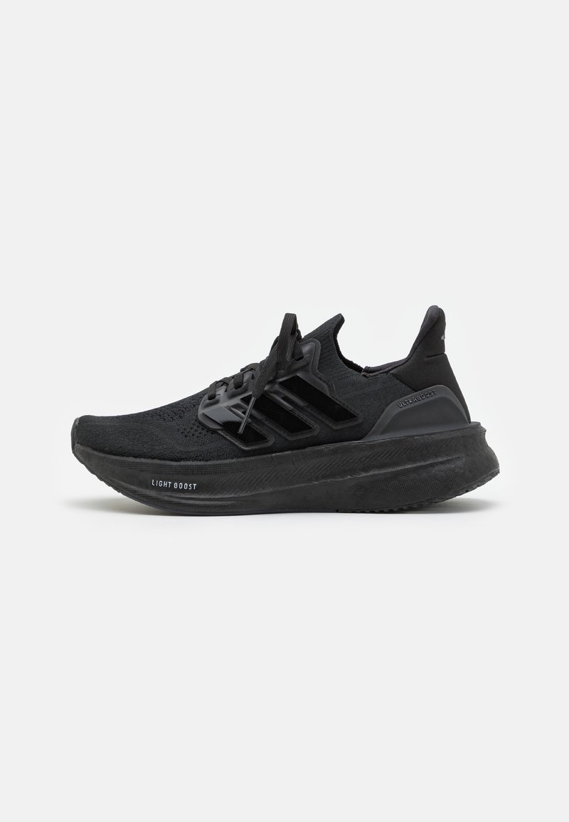 Black athletic shoes with a breathable knit upper, textured toe, prominent three-stripe design, and cushioned Lightboost sole.