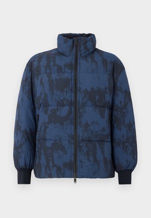 Takkiespyjakk i mørk blå med en teksturert mønster. Har høy krage, glidelåslukking og elastiske mansjetter.